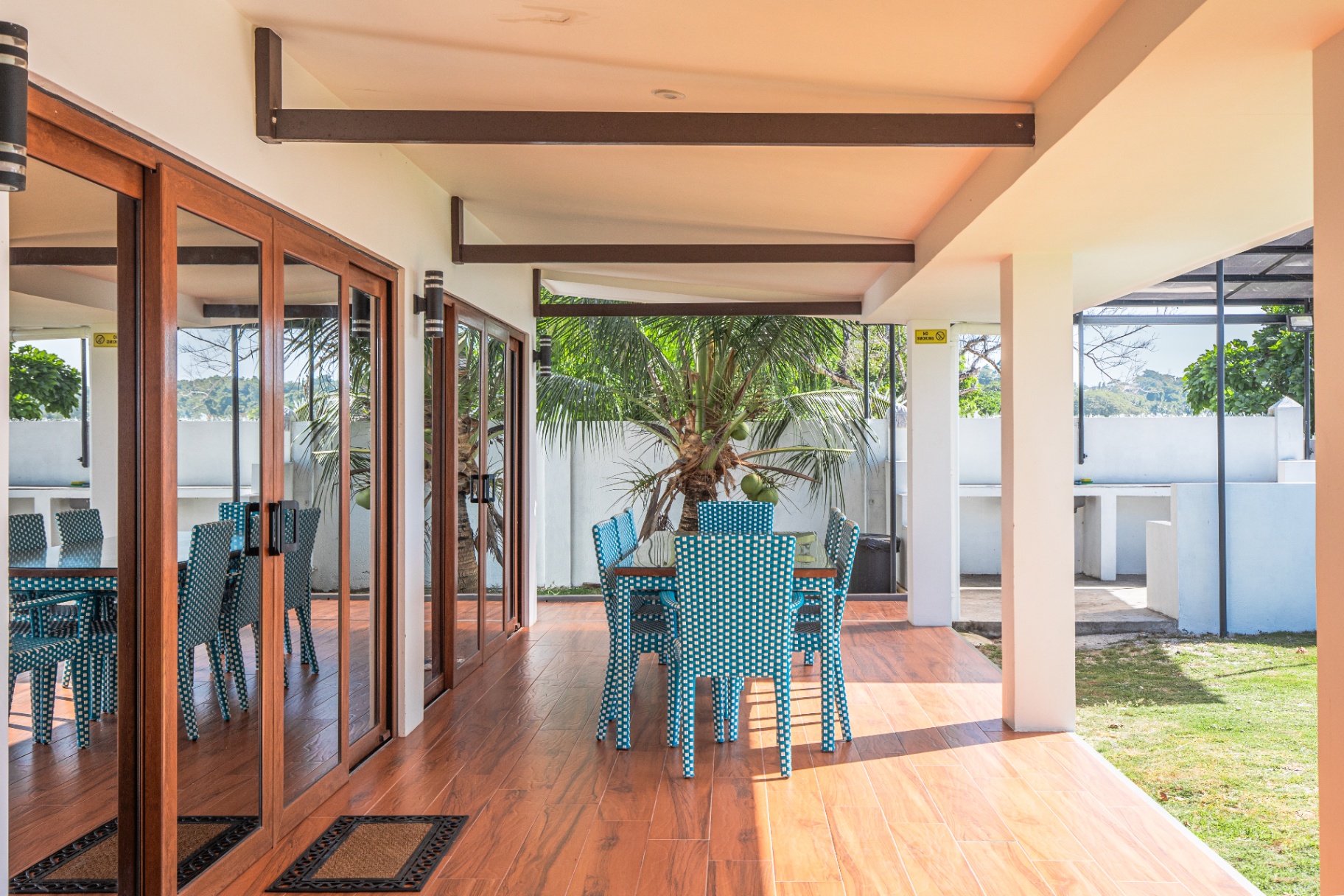 Outdoor dining terrace with palm trees and ocean breeze